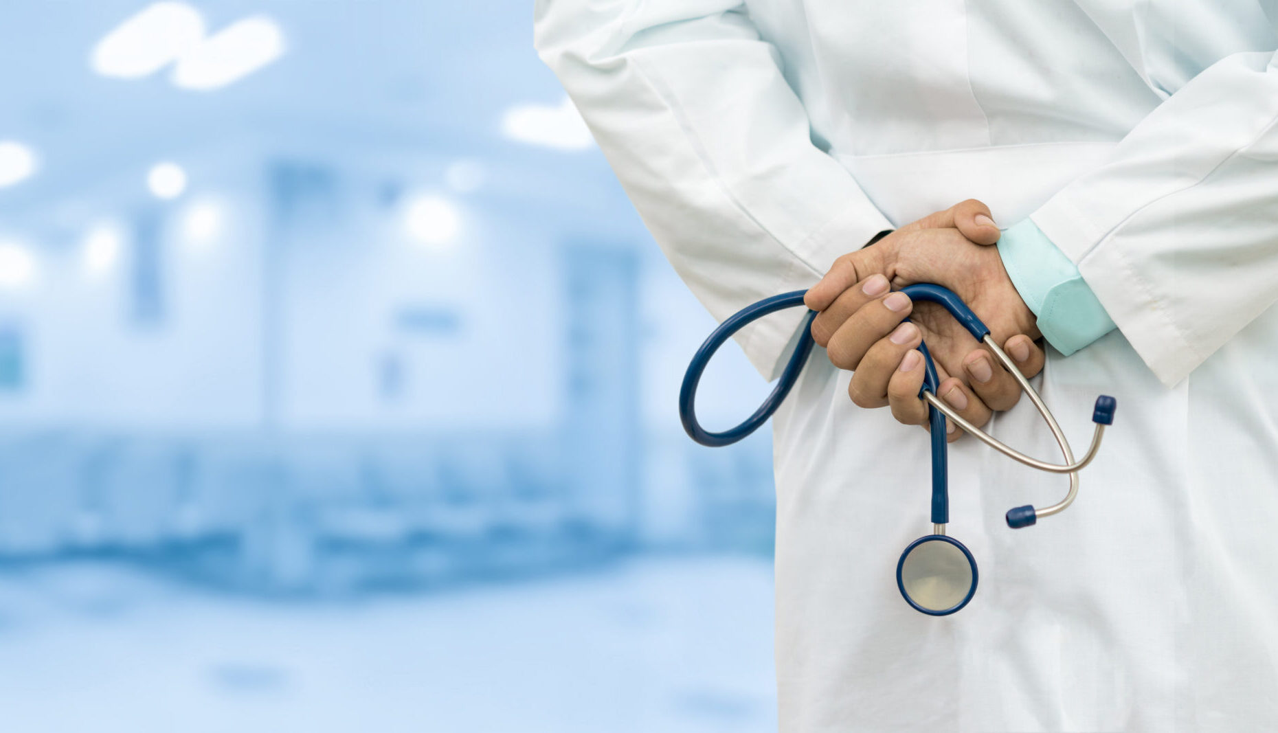 Male,Gp,Doctor,Holding,Stethoscope,In,Hospital,Or,Office.,Concept