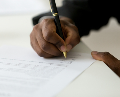 Close,Up,Of,African,American,Worker,Signing,Job,Contract,,Person