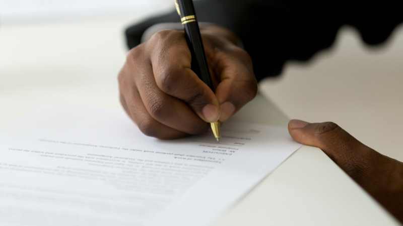 Close,Up,Of,African,American,Worker,Signing,Job,Contract,,Person