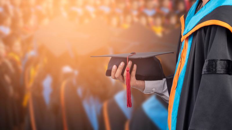 Graduates,Hold,A,Congratulatory,Hat,On,Campus.