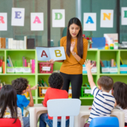 Asian,Female,Teacher,Teaching,And,Asking,Mixed,Race,Kids,Hand