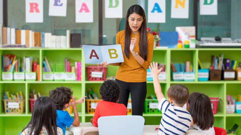 Asian,Female,Teacher,Teaching,And,Asking,Mixed,Race,Kids,Hand