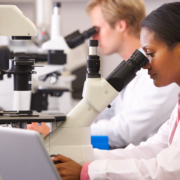 Male,And,Female,Scientists,Using,Microscopes,In,Laboratory