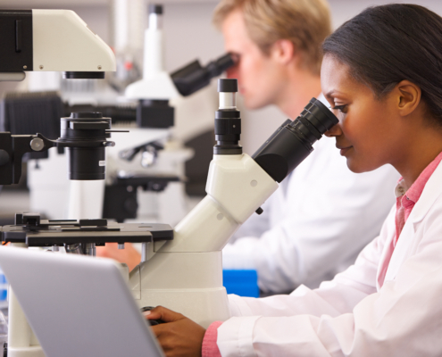 Male,And,Female,Scientists,Using,Microscopes,In,Laboratory