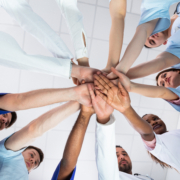 Low,Angle,View,Of,Doctor,Stacking,Hands,Together,In,Hospital