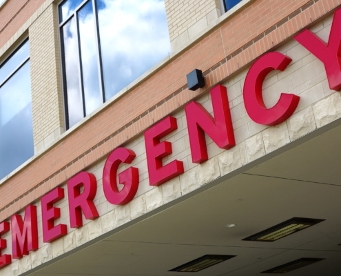 Red,Emergency,Room,Sign,On,The,Side,Of,Hospital,With