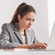 Focused,Young,Woman,Frowning,And,Typing,On,Laptop,Keyboard,While