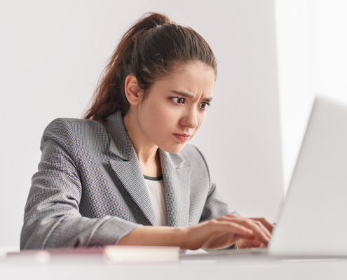 Focused,Young,Woman,Frowning,And,Typing,On,Laptop,Keyboard,While