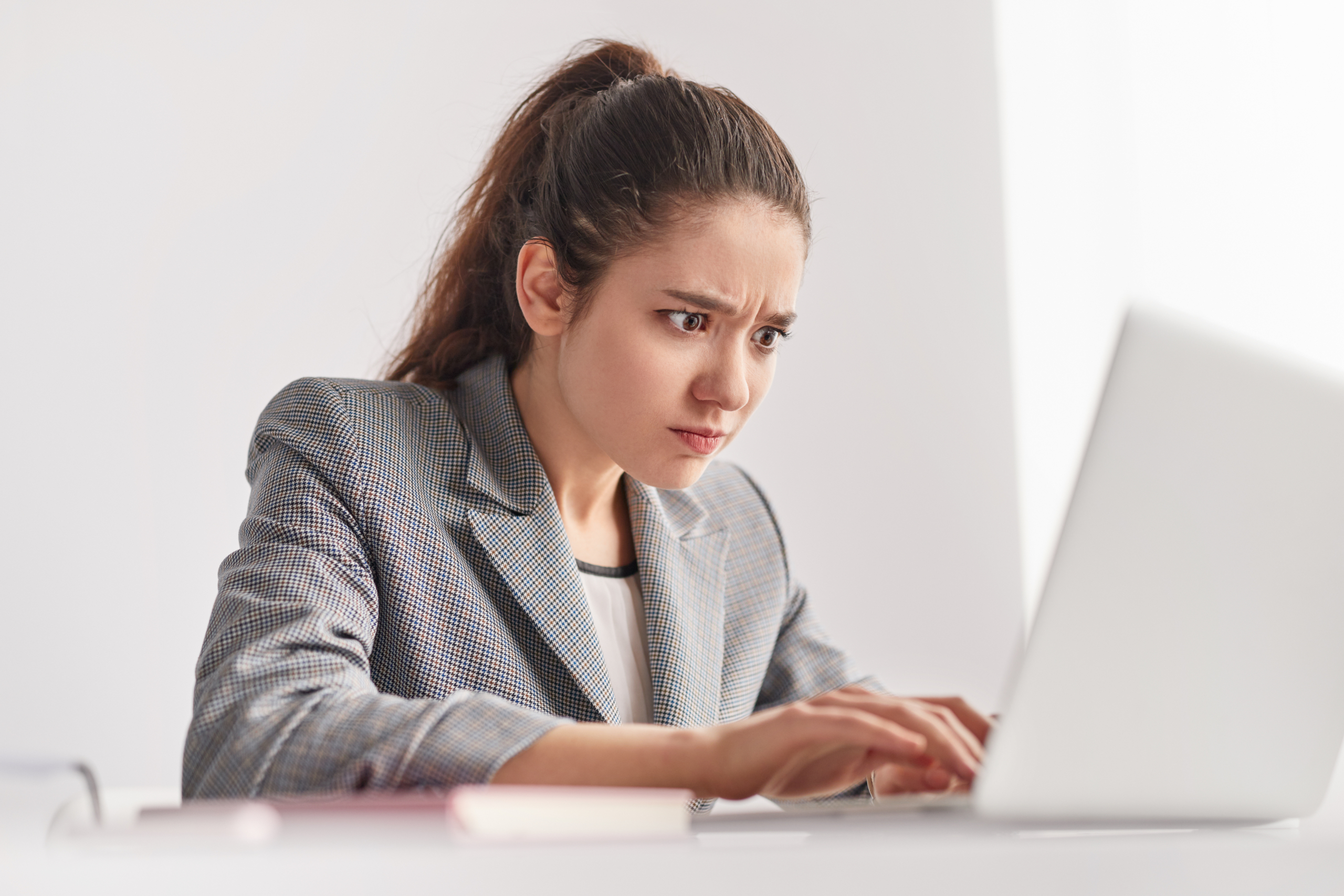 Focused,Young,Woman,Frowning,And,Typing,On,Laptop,Keyboard,While