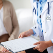Female,Doctor,Holding,Application,Form,While,Consulting,Patient