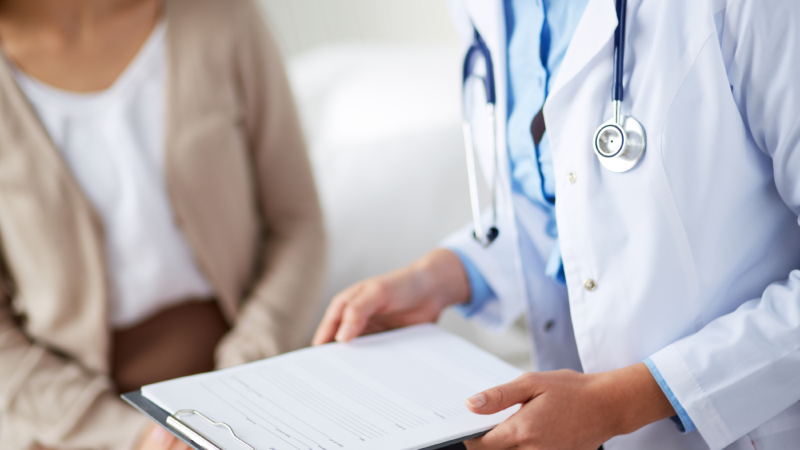 Female,Doctor,Holding,Application,Form,While,Consulting,Patient