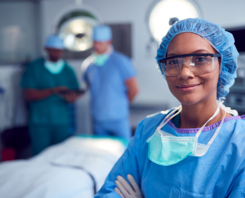 Portrait,Of,Female,Surgeon,Wearing,Scrubs,And,Protective,Glasses,In
