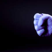 Fist,Of,Right,Man,Hand,In,A,Purple,Medical,Glove