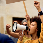 Young,African,American,Woman,With,Raised,Fist,Shouting,Through,Megaphone