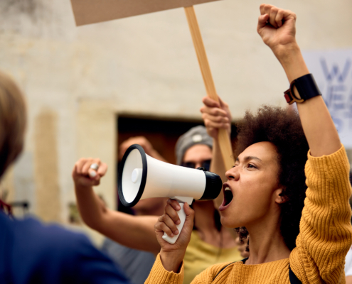 Young,African,American,Woman,With,Raised,Fist,Shouting,Through,Megaphone
