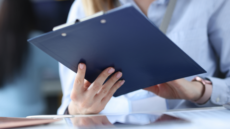 Business,Woman,Holding,Clipboard,With,Documents,In,Her,Hands,At