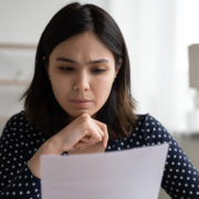 Worried,Young,Asian,Woman,Sit,At,Desk,Read,Official,Bank