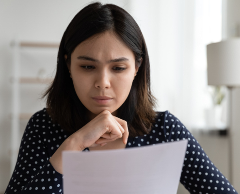 Worried,Young,Asian,Woman,Sit,At,Desk,Read,Official,Bank