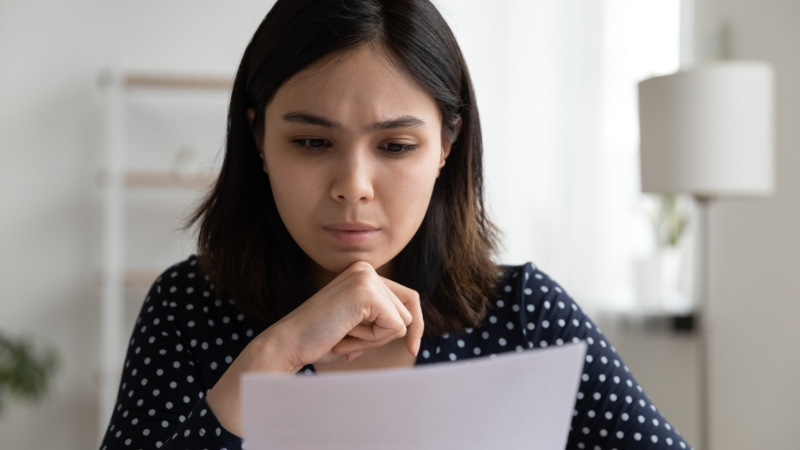 Worried,Young,Asian,Woman,Sit,At,Desk,Read,Official,Bank