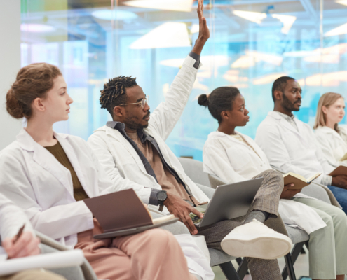 Multi-ethnic,Group,Of,People,Wearing,Lab,Coats,Sitting,In,Row