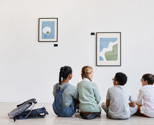 Back,View,At,Diverse,Group,Of,Children,Sitting,On,Floor