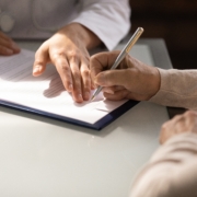 Hands,Of,Woman,Filling,Document,At,Appointment,In,Doctor,Office.