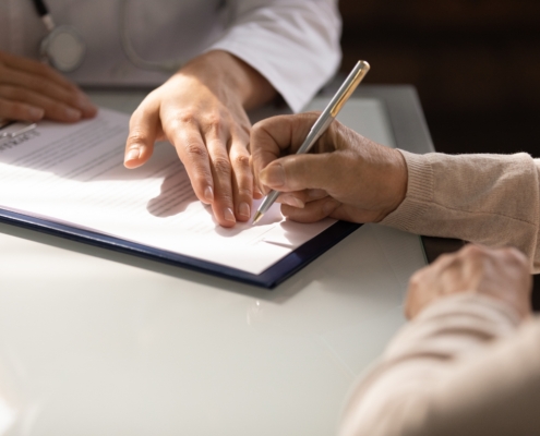 Hands,Of,Woman,Filling,Document,At,Appointment,In,Doctor,Office.