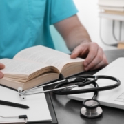 Medical,Student,In,Uniform,Studying,At,Table,Indoors,,Closeup