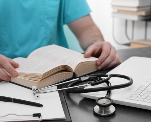 Medical,Student,In,Uniform,Studying,At,Table,Indoors,,Closeup