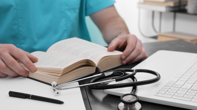 Medical,Student,In,Uniform,Studying,At,Table,Indoors,,Closeup