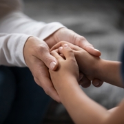 Close,Up,Compassionate,Young,Foster,Parent,Holding,Hands,Of,Little