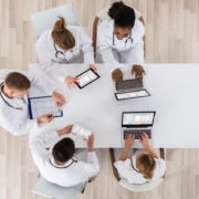 Medical,Doctor,Group,Meeting,At,Desk,With,Laptop,Computer