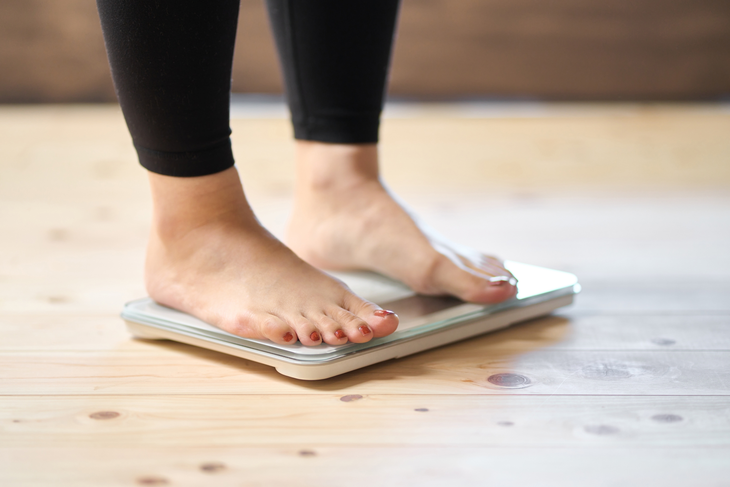 Feet,Of,An,Asian,Woman,On,A,Weight,Scale