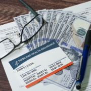 Fake,Medicare,Cardand,Fake,Cash,With,Eyeglasses,And,A,Pen.