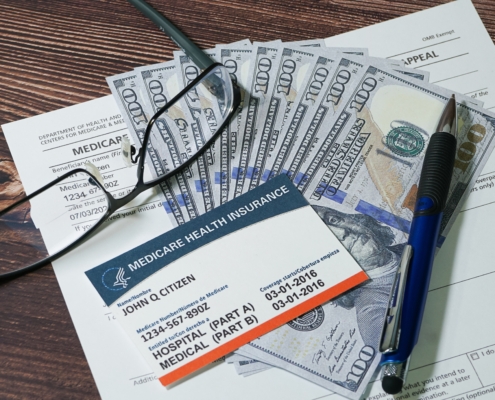 Fake,Medicare,Cardand,Fake,Cash,With,Eyeglasses,And,A,Pen.