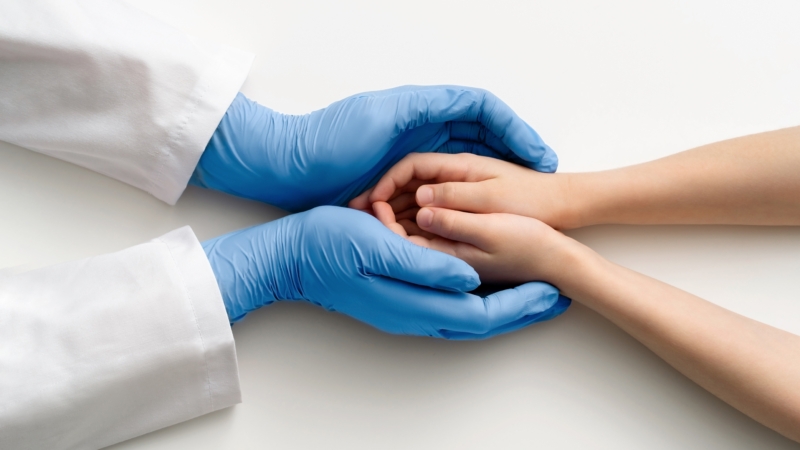 The,Doctor’s,Gloved,Hands,Hold,The,Child’s,Hands.,Medical,Concept.