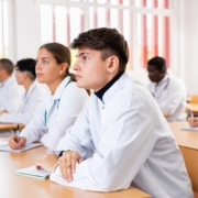 Young,Man,Medical,Student,In,White,Coat,Attedning,Classes,In