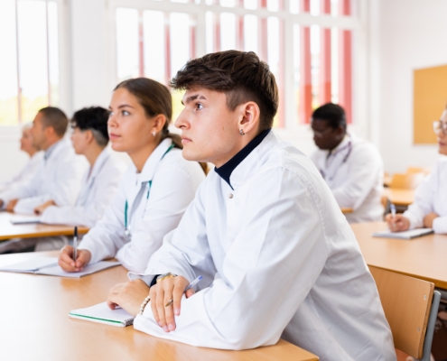 Young,Man,Medical,Student,In,White,Coat,Attedning,Classes,In
