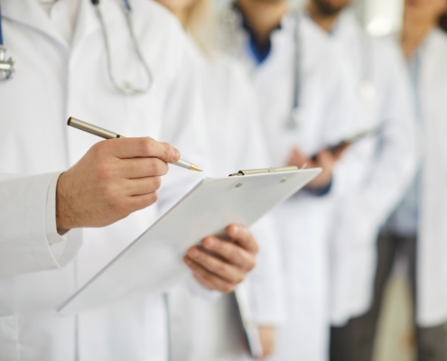 Professional,Doctor,Wearing,Uniform,Taking,Notes,In,Clipboard,Journal,,Physician