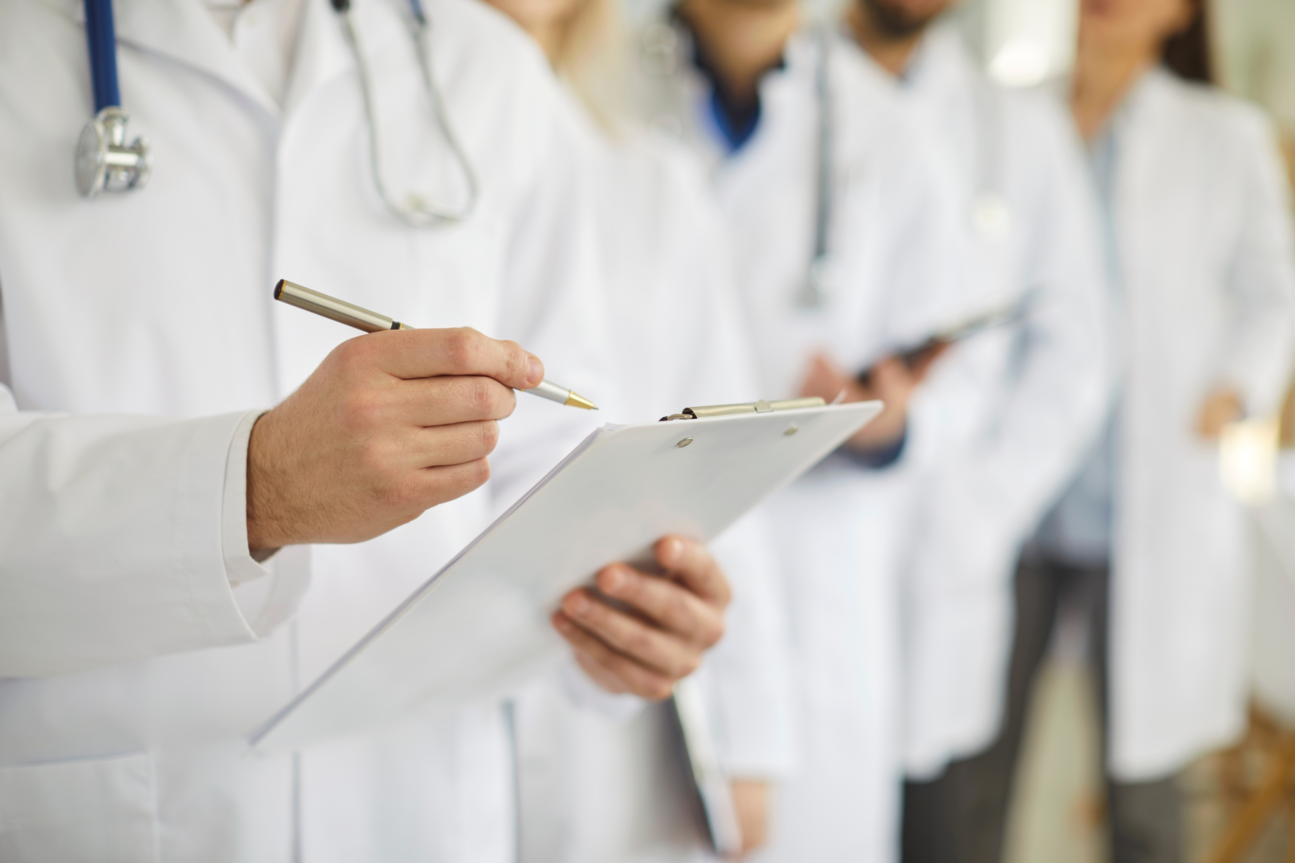 Professional,Doctor,Wearing,Uniform,Taking,Notes,In,Clipboard,Journal,,Physician