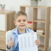 School,Grade.,Happy,Boy,Holding,Answer,Sheet,With,Letter,A