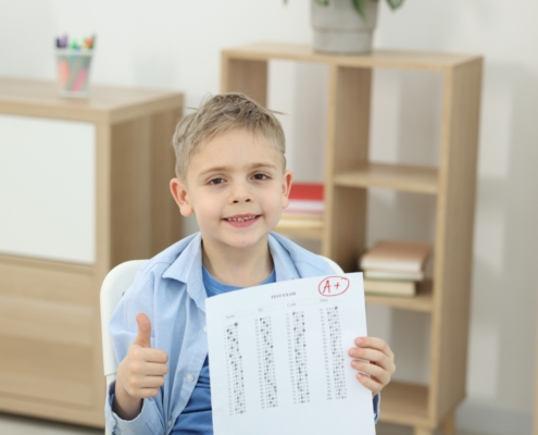 School,Grade.,Happy,Boy,Holding,Answer,Sheet,With,Letter,A