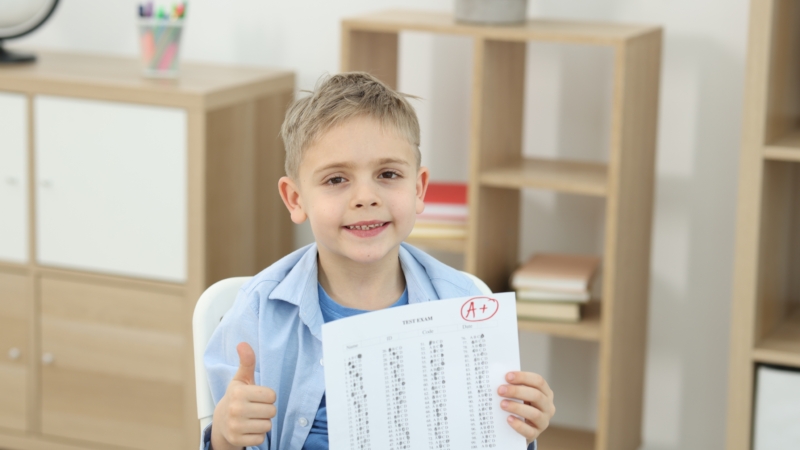 School,Grade.,Happy,Boy,Holding,Answer,Sheet,With,Letter,A