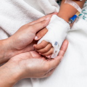Mother,Holding,Child’s,Hand,Who,Have,Iv,Solution,In,The