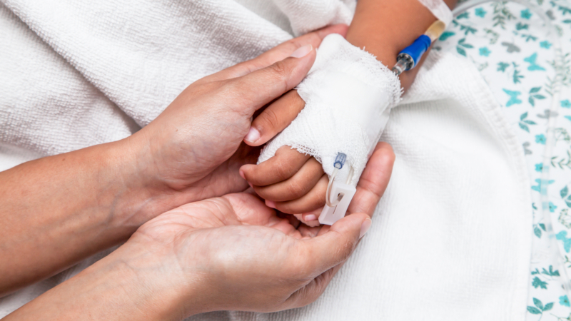 Mother,Holding,Child’s,Hand,Who,Have,Iv,Solution,In,The