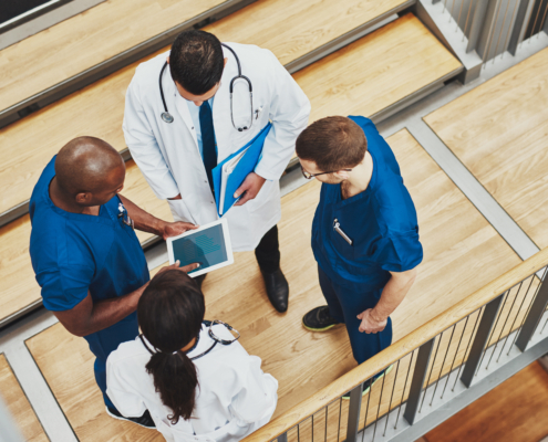 Multiracial,Medical,Team,Having,A,Discussion,As,They,Stand,Grouped