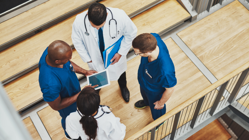 Multiracial,Medical,Team,Having,A,Discussion,As,They,Stand,Grouped