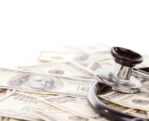 Stethoscope,Laying,On,Stacks,Of,Hundred,Dollar,Bills,With,Narrow