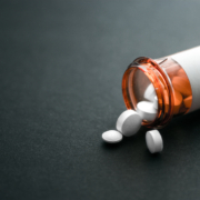 White,Pills,Spilling,Out,Of,A,Toppled,Bright,Red,Orange