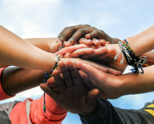 Multiracial,Teenagers,Joining,Hands,Together,In,Cooperation